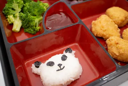 Rice panda and broccoli with tempura chicken in a kid's bento box from Temaki