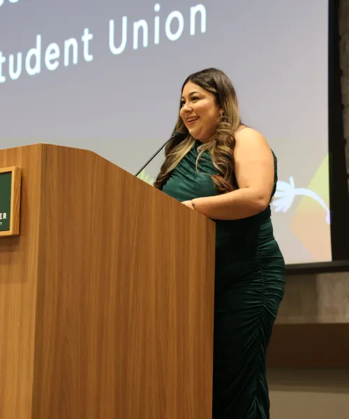Rosie at a podium in a green dress