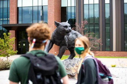 Stock photo of two students near the wildcat statue