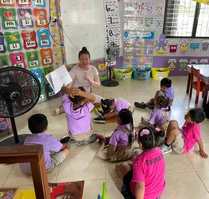 A student reading to a group of students in their Belize classroom