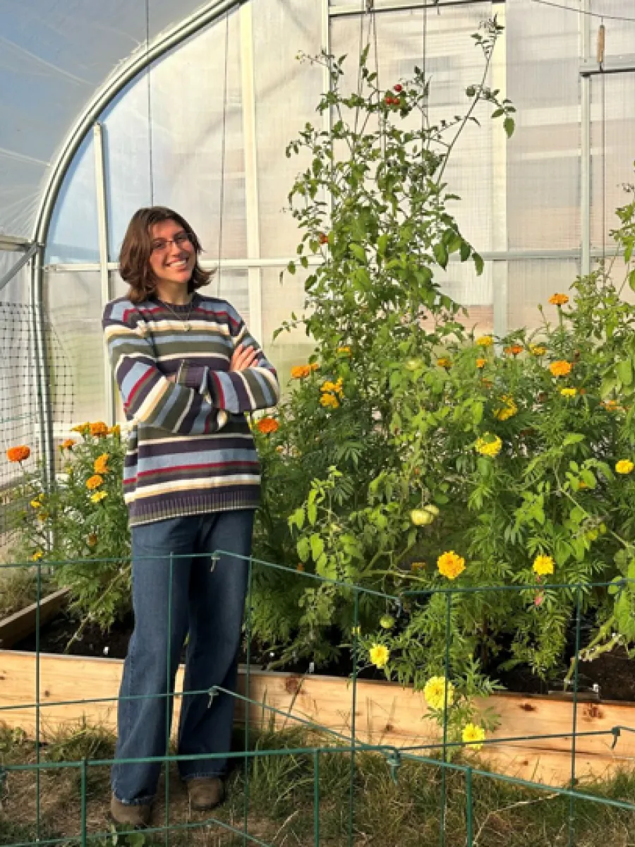 Alexis Shea posing near the tomatoes in the Hoop House