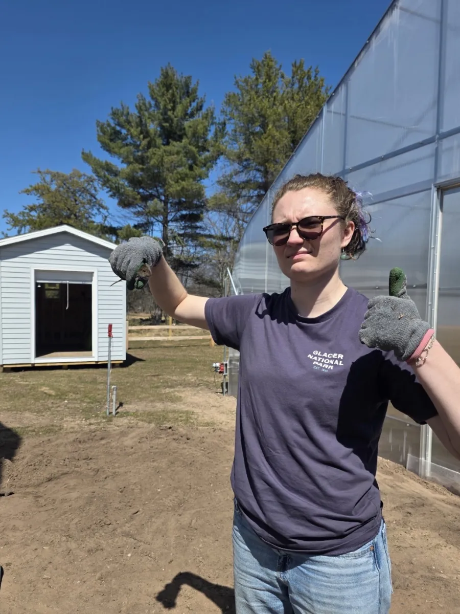 Abby Owen holding a mole outside of the Hoop House