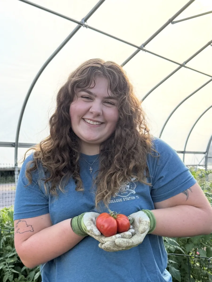 Savannah holding tomatoes harvested from the Hoop House