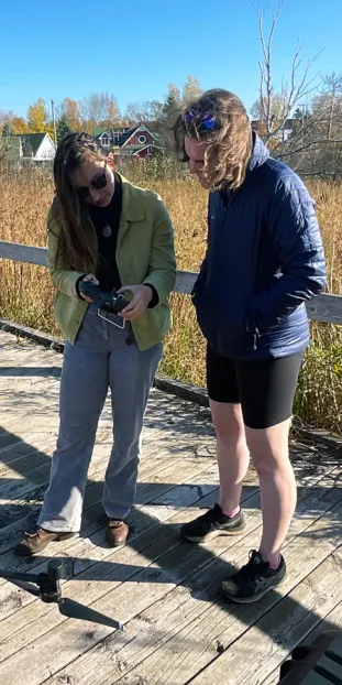 Students programming drone for flight over Presque Isle Mitigation Wetlands