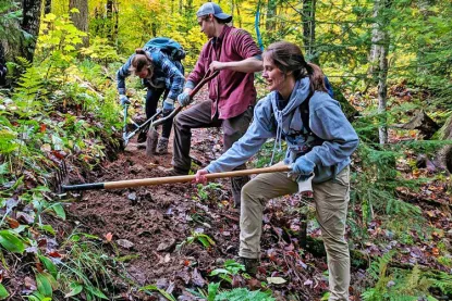 Student on the NMU Conservation Crew maintaining a trail.