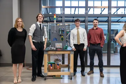 Senior Engineering Technology students standing next to the contact verification system they created for Moeller Aerospace as their senior capstone project during the 2025-26 academic year.