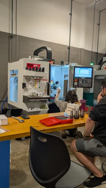 Students working on a project using a Haas minimill in the manufacturing lab located in the NMU Jacobetti Complex