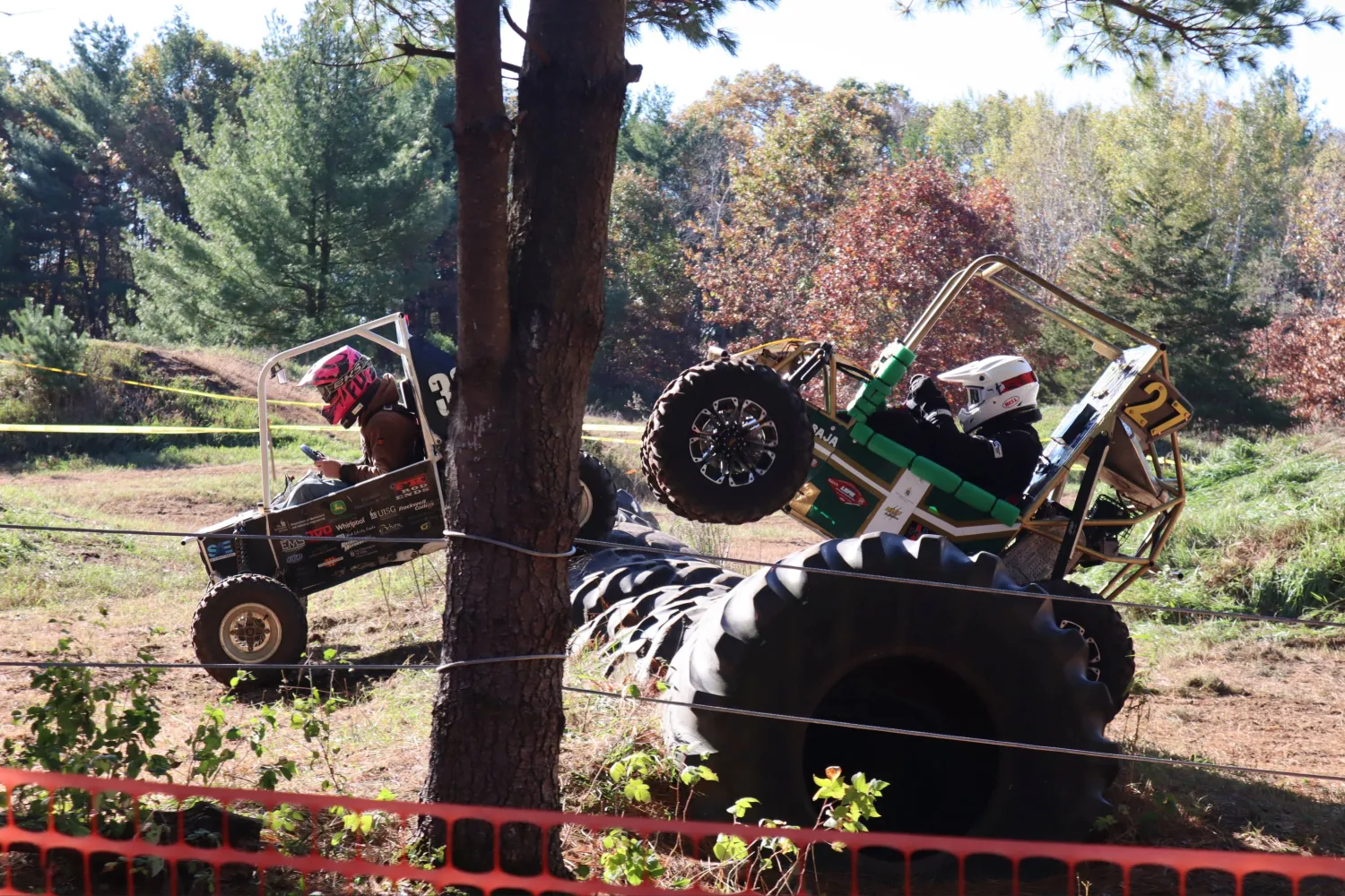 Baja vehicles racing over giant tires on the track.  The NMU vehicle is balancing on its rear axel.  