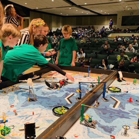 students talking with referee during robot table match