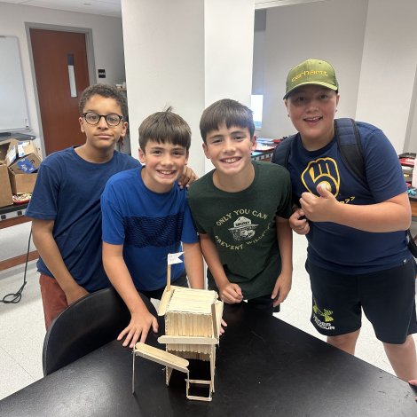 students showing model of fort built out of popsicle sticks