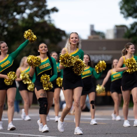 NMU cheerleaders walking in a parade on the street 