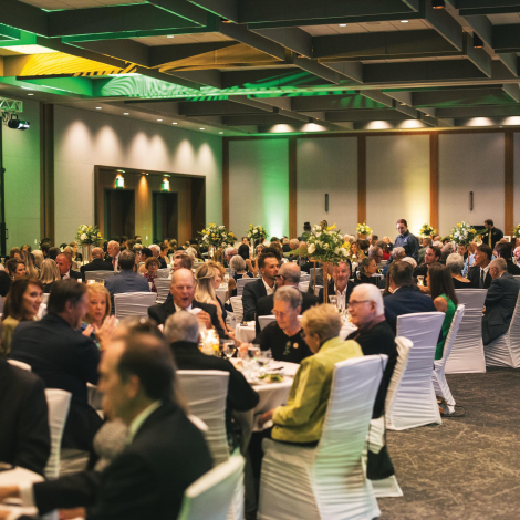 A large room filled with NMU alumni and community members eating dinner.