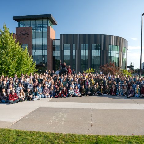 NMU Staff gathered in front of the Wildcat statue in their plaid