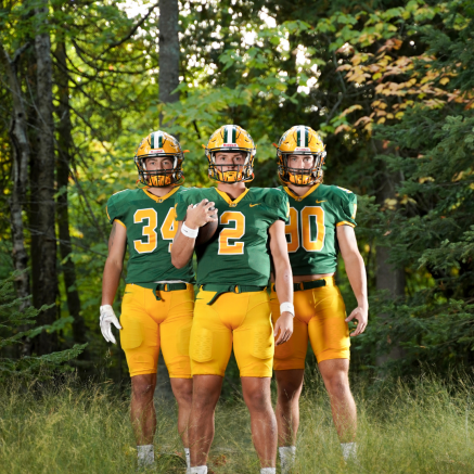 three football players standing in the woods