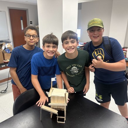 students showing model of fort built out of popsicle sticks