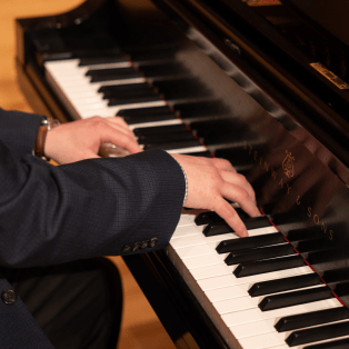close up of a man's hands playing a piano