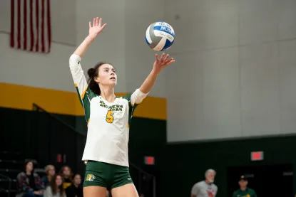 NMU volleyball player getting ready to serve