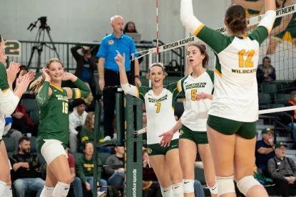 NMU volleyball players celebrate a point
