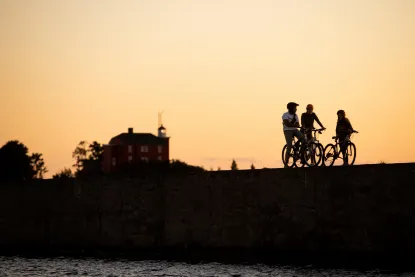 Students on bikes by the lake during the sunrise