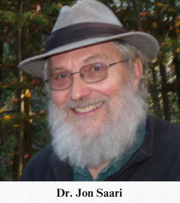 An older Dr. Jon Saari smiles at the camera, his grey fedora matching his grey beard.