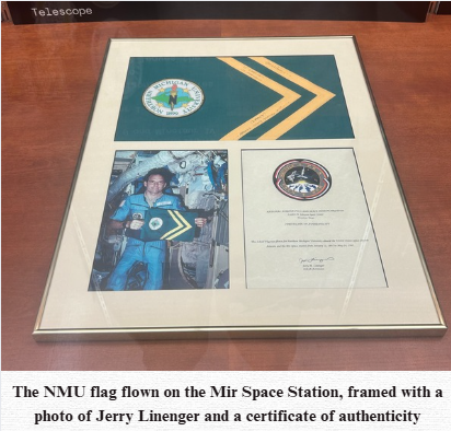A frame holding the NMU space flag, with a photo of Jerry Linenger and a certificate of authenticity