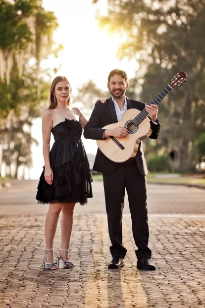 Deux Saison (voice and guitar duo) posed on street on a sunny day