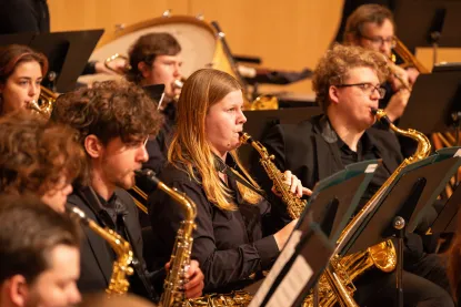 Student saxophonists and trombone players performing with the NMU Wind Ensemble in Reynolds Recital Hall.