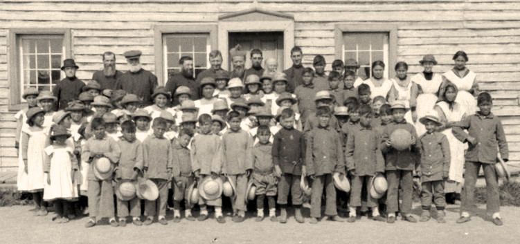 Officials and schoolchildren outside Providence Mission Indian Residential School, Fort Providence, Northwest Territories.  Source: Library and Archives Canada