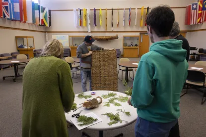 Three individuals gather in a room to connect with nature through craftsmanship