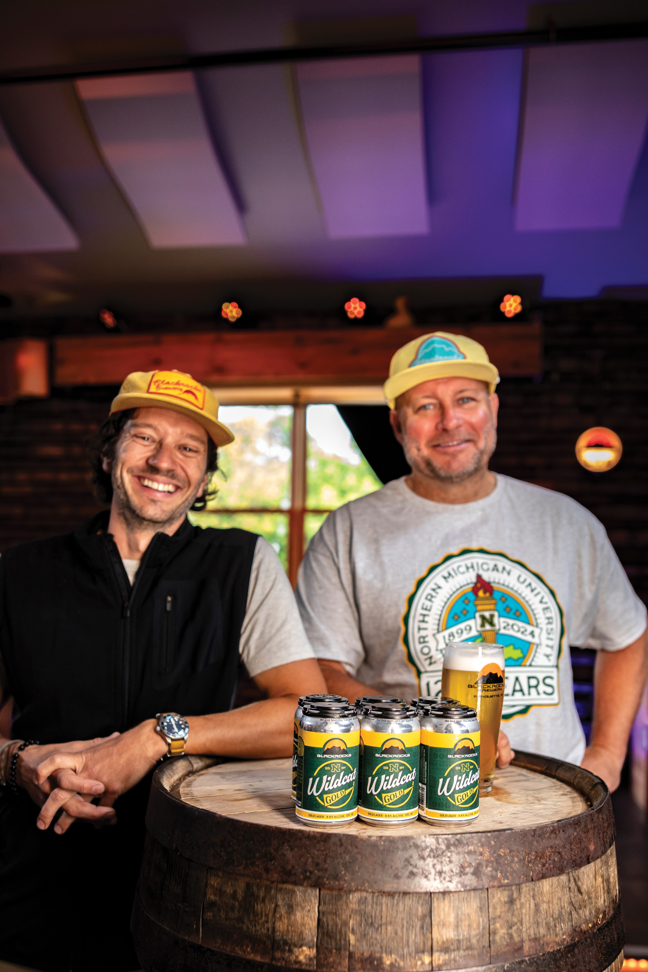 Steve Farr and Andy Langlois with cans of Wildcat Gold on a barrel