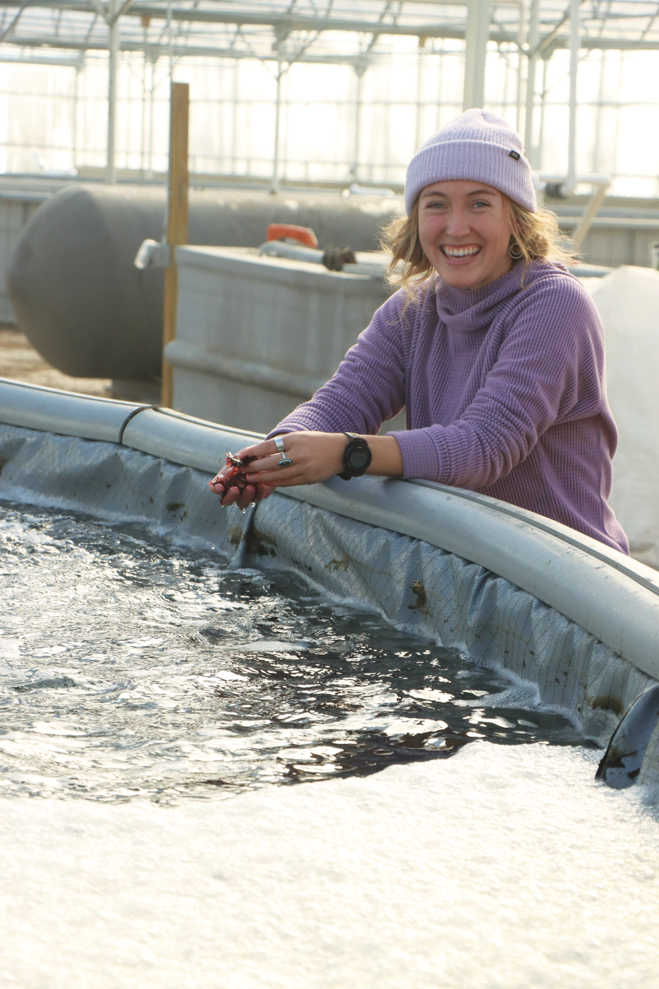Woman standing by an inflatable pool in greenhouse