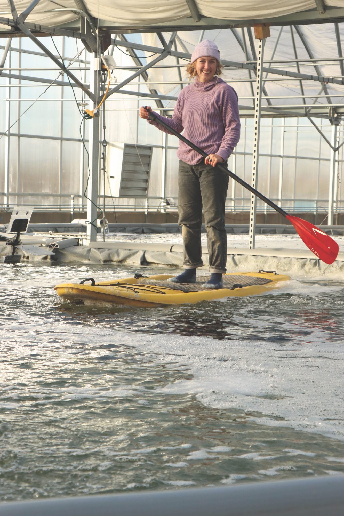 Woman on paddleboard in greenhouse