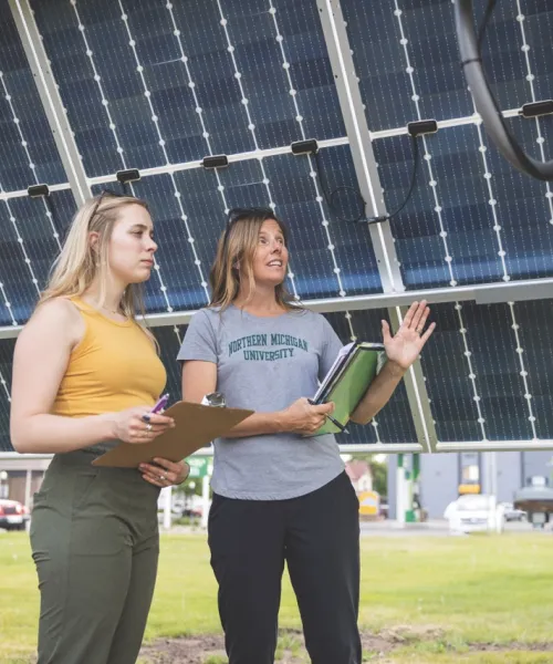 Professor and student inspecting solar array
