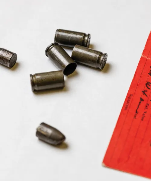 Four bullets and casings next to evidence tag