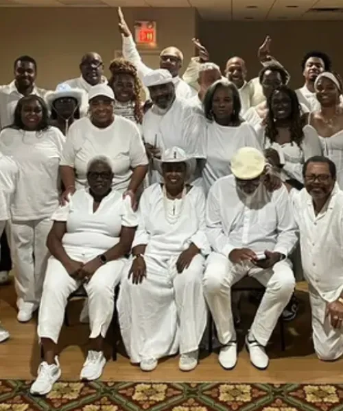 Large group of people dressed in white posing and having fun