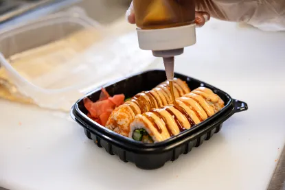 sauce being poured onto sushi