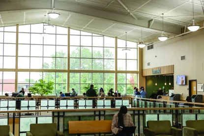 large interior wall of windows and students sitting at tables