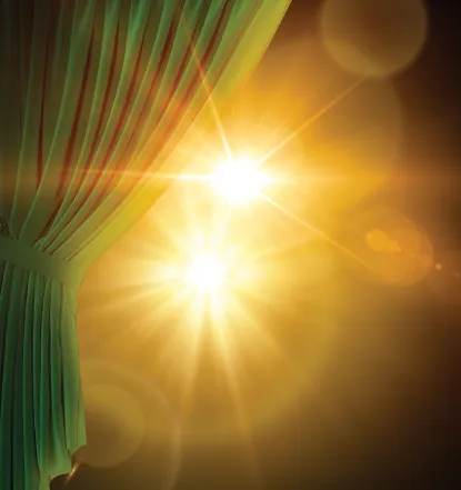 Golden lights shining behind a green stage curtain.