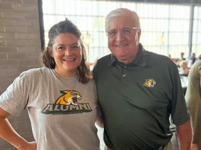 Two NMU Alumni smiling together at an alumni event.