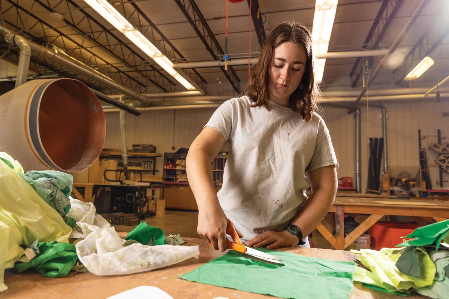 Student cutting fabric in costume shop