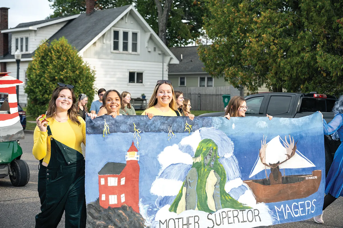 Students in parade with painted Magers Hall sign