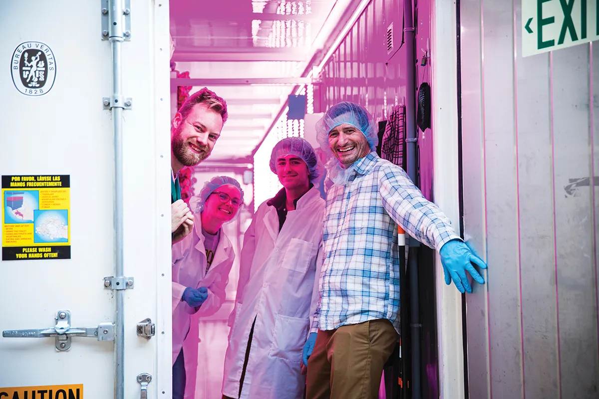 Professor and students at door of growing shipping container