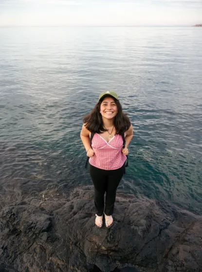 Citlali standing on a rock in front of Lake Superior