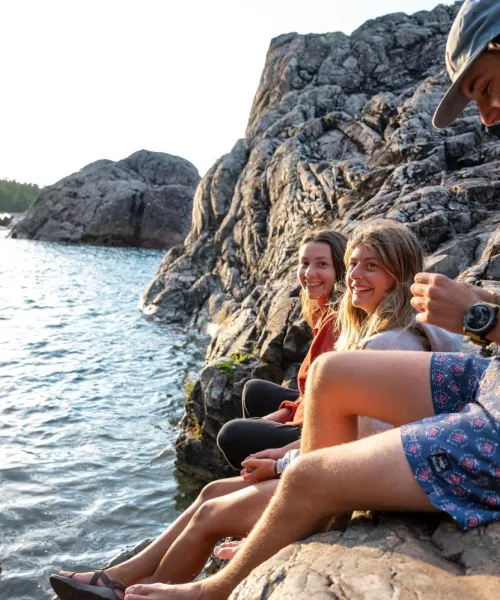 Students sitting on rocks near Lake Superior