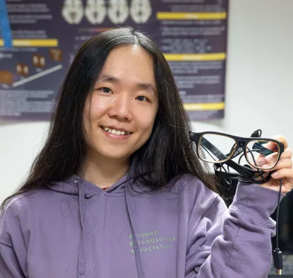 Dr. Lin Fang holding eye tracking glasses
