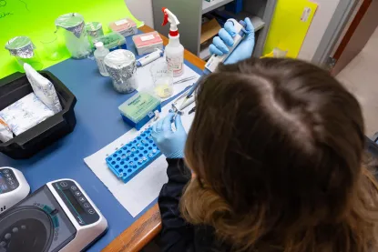 Student in LaCrosse lab holds a pipettor 