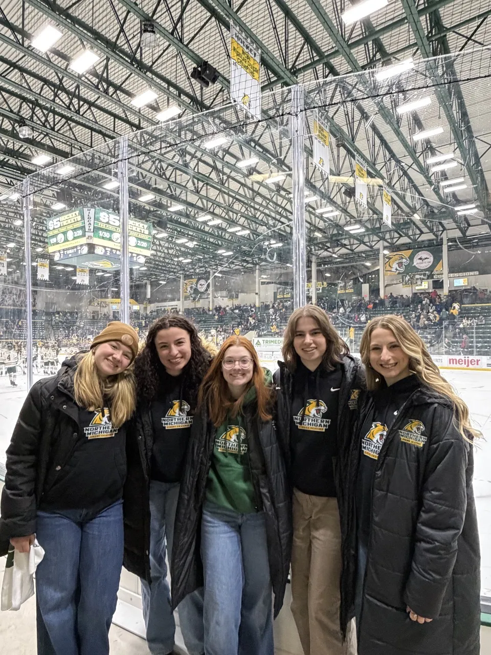 Five figure skater at a hockey game supporting the Wildcats.