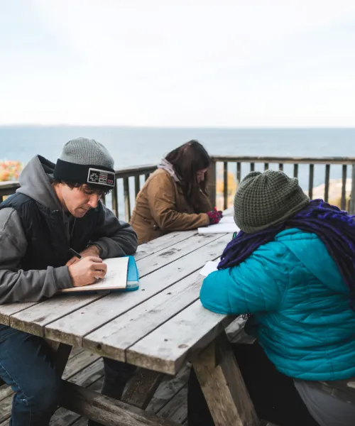 Students working at a picnic table on Granite Island.