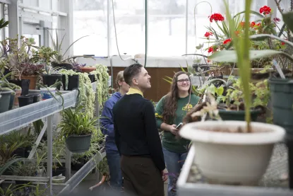 Students working in NMU's greenhouse with a faculty member