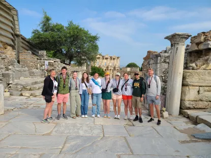 A group of NMU students in Greece posting in front of ancient ruins